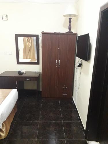 a bedroom with a cabinet and a desk and a bed at Lake Hotel in Mūkhī