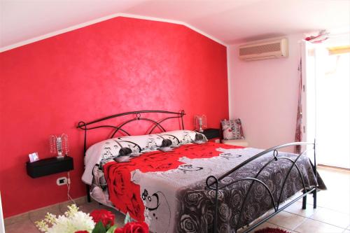 a bedroom with a red wall and a bed at Emotions in Fiumicino