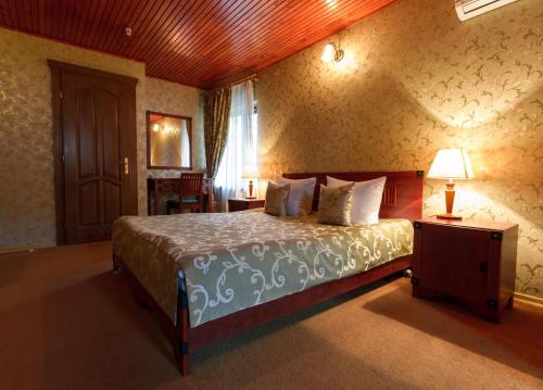 a bedroom with a bed and a table with a lamp at Letuchiy Gollandets in Uzhhorod