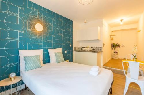 - 2 lits dans une chambre avec un mur bleu dans l'établissement Apartments WS St Germain - Quartier Latin, à Paris