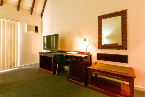 a room with a desk with a computer and a mirror at Sanno Marracoonda Perth Airport Hotel in Perth