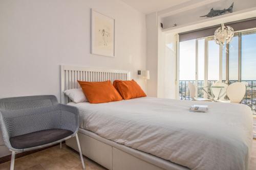 1 dormitorio con 1 cama con silla y ventana en Holidays Penthouse vues panoramiques sur le Port naval,un séjour élégant assuré " Wifi Pàrquing gratuït, en Roses