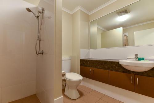 a bathroom with a sink and a toilet and a mirror at Sanno Marracoonda Perth Airport Hotel in Perth