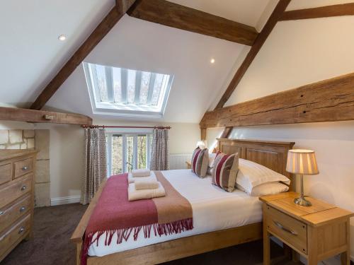 a bedroom with a large bed and a skylight at St Kenelm in Winchcombe