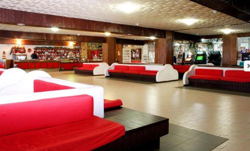 a restaurant with red and white couches and a bar at monolocale paradiso aremogna in Roccaraso