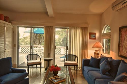 a living room with a blue couch and a patio at Hacienda Todos Los Santos in Todos Santos
