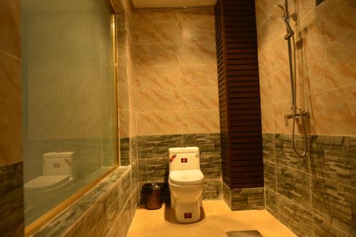 La salle de bains est pourvue d'une douche et de toilettes. dans l'établissement Summit Inn, à Longpan