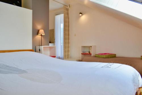 a bedroom with a white bed and a staircase at Location Le Queron in Guillestre