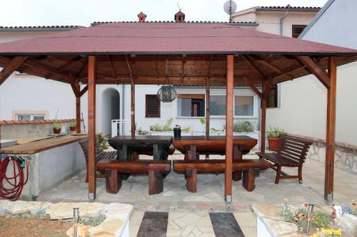 un padiglione in legno con tavolo e panche su un patio di Apartment Zeljko 63 a Pola (Pula)