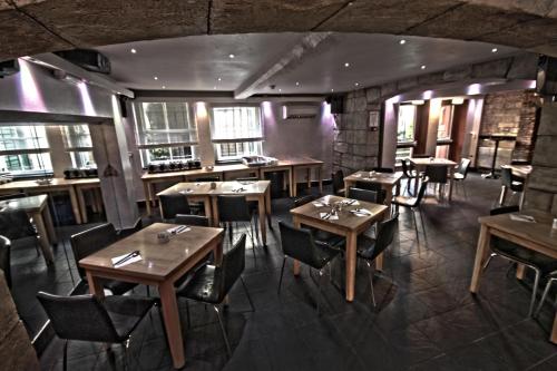 a restaurant with wooden tables and chairs and windows at The George Hotel in Whitby