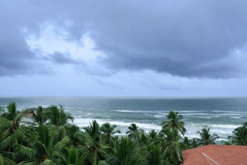 a view of a beach with palm trees and the ocean at Gokulam Grand Turtle On The Beach in Kovalam