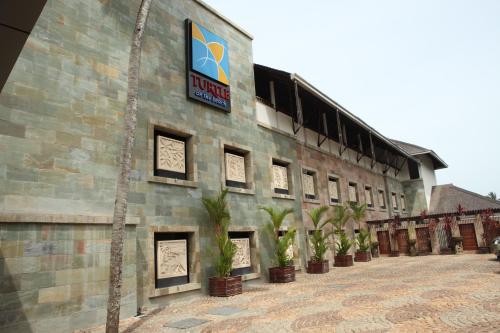 a building with potted plants on the side of it at Gokulam Grand Turtle On The Beach in Kovalam
