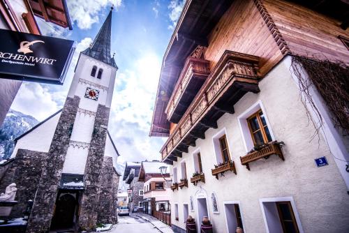 a tall building with a clock tower on a street at Bergparadies - inklusive Eintritt in die Alpentherme in Dorfgastein