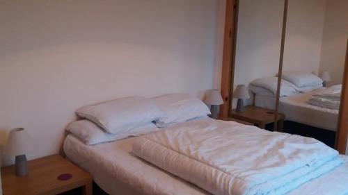 una camera da letto con due letti e uno specchio di Mey Cliff Cottage a Scarfskerry