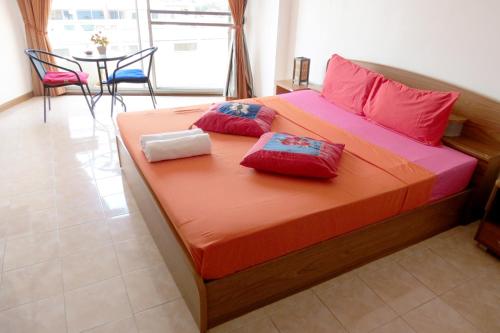 ein Bett mit zwei Kissen und einem Tisch in einem Zimmer in der Unterkunft View Talay 1 Jomtien in Pattaya South