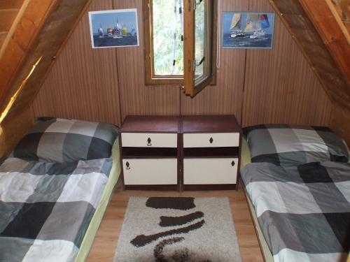 バラトンマーリアフュルドゥーにあるVitorlás Nyaralóházのベッド2台と窓が備わる小さな客室です。