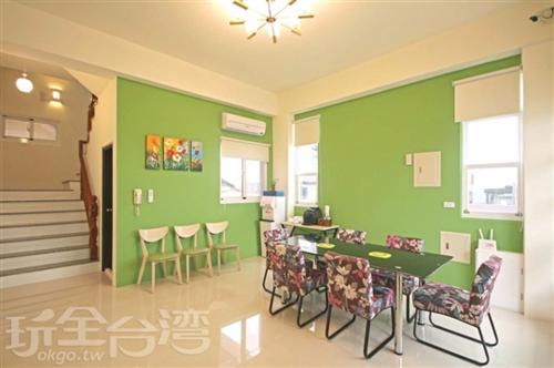 a room with a green wall with chairs and a table at Hai Bed and Breakfasts in Taitung City