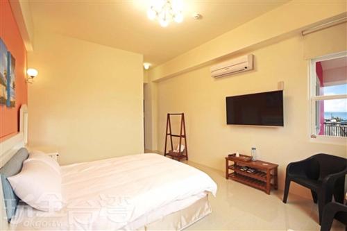 a bedroom with a bed and a flat screen tv at Hai Bed and Breakfasts in Taitung City