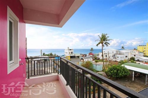 a balcony of a pink house with a view of the ocean at Hai Bed and Breakfasts in Taitung City