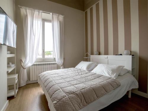 a bedroom with a white bed and a window at Casa Desy in Forte dei Marmi