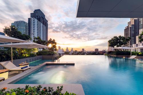 a swimming pool with a city skyline in the background at Somerset Sukhumvit Thonglor in Bangkok