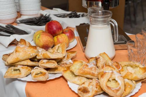 un tavolo con un piatto di pasticcini, mele e latte di Domki Diament a Pobierowo