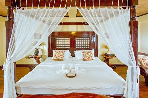 a bedroom with a bed with a white canopy at Nabulao Beach and Dive Resort in Hinoba-an