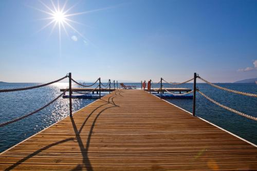 une jetée en bois avec un pont sur l'eau dans l'établissement Flow Datca Surf & Beach Hotel, à Datça