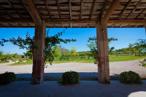 a view from the inside of a pavilion with a dirt field at Agriturismo con Cucina tipica Nuova Scardua in Cavriana