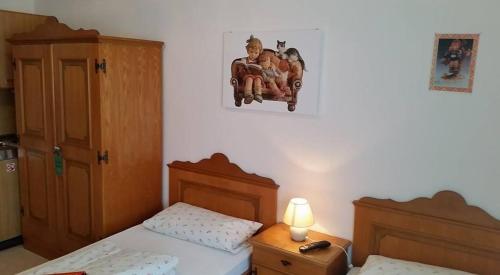 a small bedroom with two beds and a lamp at Gasthaus Mösle in Reute