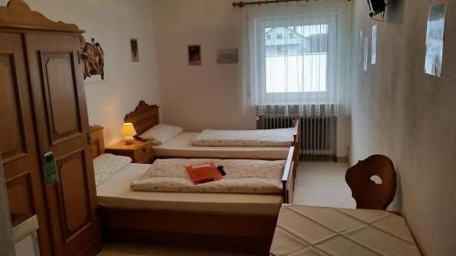 1 Schlafzimmer mit 2 Betten, einem Fenster und einem Stuhl in der Unterkunft Gasthaus Mösle in Oberreute