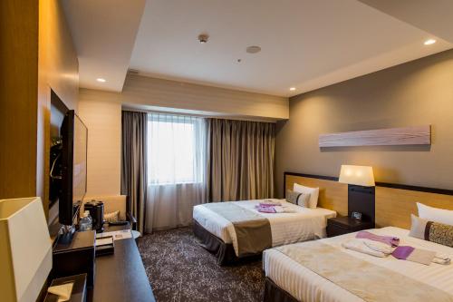 Habitación de hotel con 2 camas y TV de pantalla plana. en Hotel Ole, en Fujieda