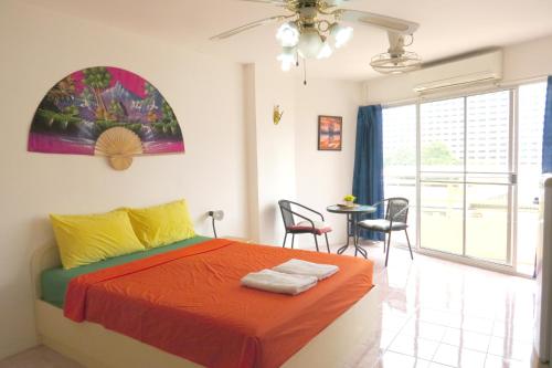 芭達雅南區的住宿－塔萊景緻1B假期公寓，卧室配有一张床和一张桌子及椅子