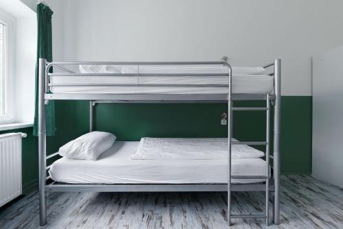 two bunk beds in a room with a green wall at Ballhaus Berlin Hostel in Berlin