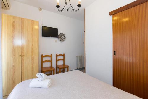 a bedroom with a bed with a towel at Pension Mesones in Granada
