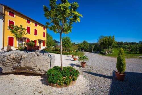 a building with plants and a tree in a yard at Agriturismo con Cucina tipica Nuova Scardua in Cavriana
