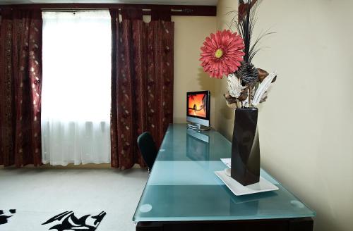 a glass table with a vase with a flower on it at Desalis Hotel London Stansted in Elsenham