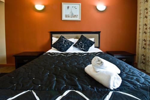a bedroom with a bed with two towels on it at Desalis Hotel London Stansted in Elsenham