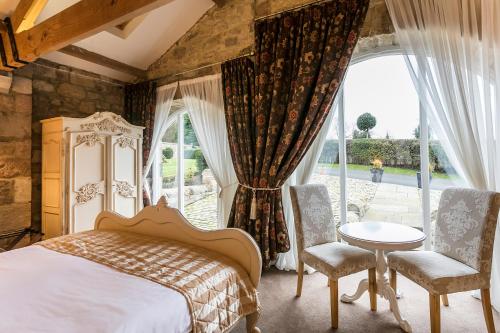 a bedroom with a bed and a large window at Doxford Hall Hotel And Spa in Alnwick