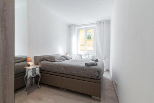 ein weißes Schlafzimmer mit einem Bett und einem Fenster in der Unterkunft LE ROSSETTI 2 - F2 LUMINEUX, ASCENSEUR, CLIMATISATION, COEUR Vieux-Nice in Nizza