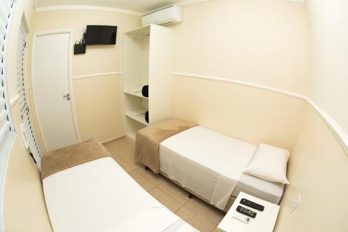 um pequeno quarto com uma cama e um espelho em Residencial Villa Container em Campinas