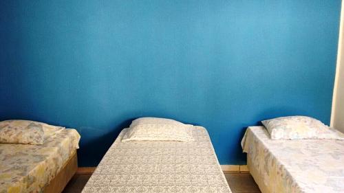 2 łóżka w pokoju z niebieską ścianą w obiekcie Pousada CPA w mieście Cuiabá