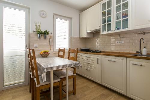 a kitchen with white cabinets and a table and chairs at Truly Mediterranean Apartment "Spark" in Korčula