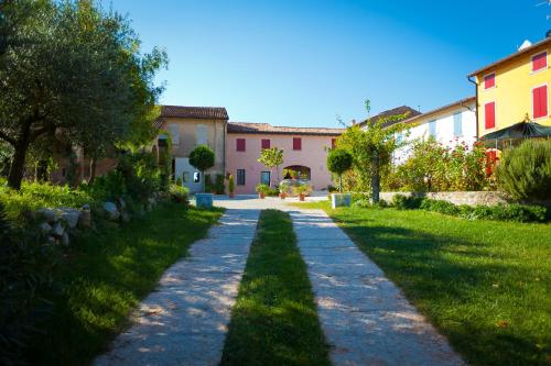 a stone path in a yard with buildings at Agriturismo con Cucina tipica Nuova Scardua in Cavriana