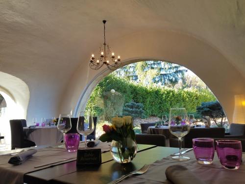 une table avec des verres à vin et un vase avec des fleurs dans l'établissement L'Oustaou, à Château-Arnoux-Saint-Auban