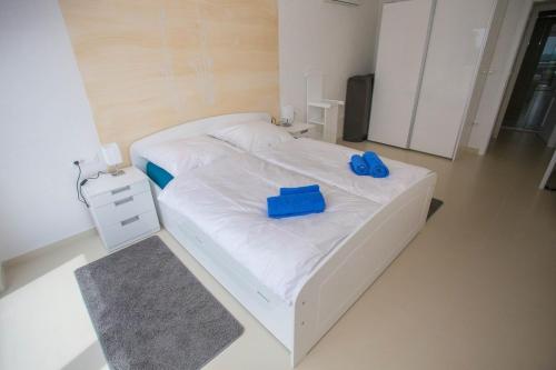 Un dormitorio con una cama blanca con zapatos azules. en Villa Sunce, en Kaštelir