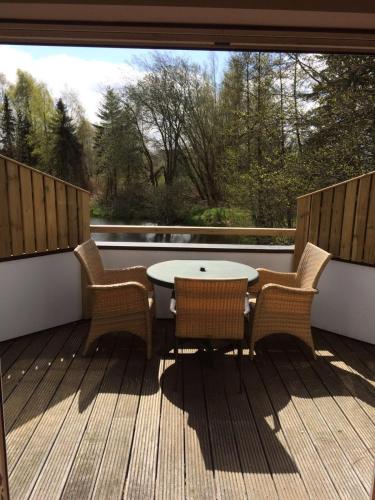 a patio with a table and chairs on a deck at Moderne Maisonette-Wohnung am Karpfenteich; modern Apartment with view of the carp pond in Barmstedt