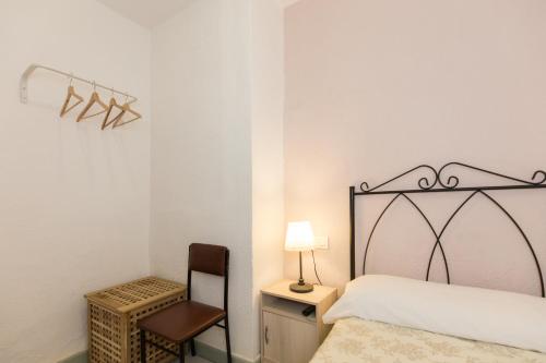 a bedroom with a bed and a desk and a chair at Pension Mesones in Granada