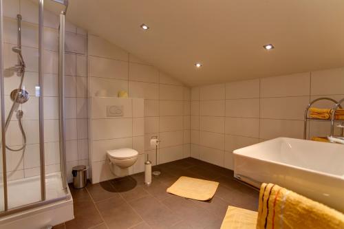 a bathroom with a tub and a toilet and a sink at Haus Mattle in Pettneu am Arlberg