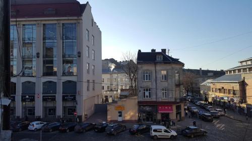 a city street with cars parked in front of buildings at Soprano apartment in Lviv